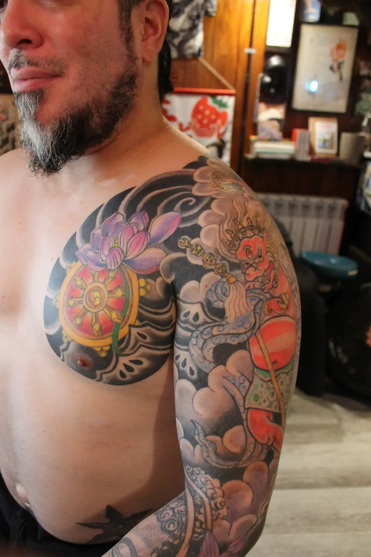 Loto en tatuaje japonés con fondo oscuro y elementos budistas alrededor