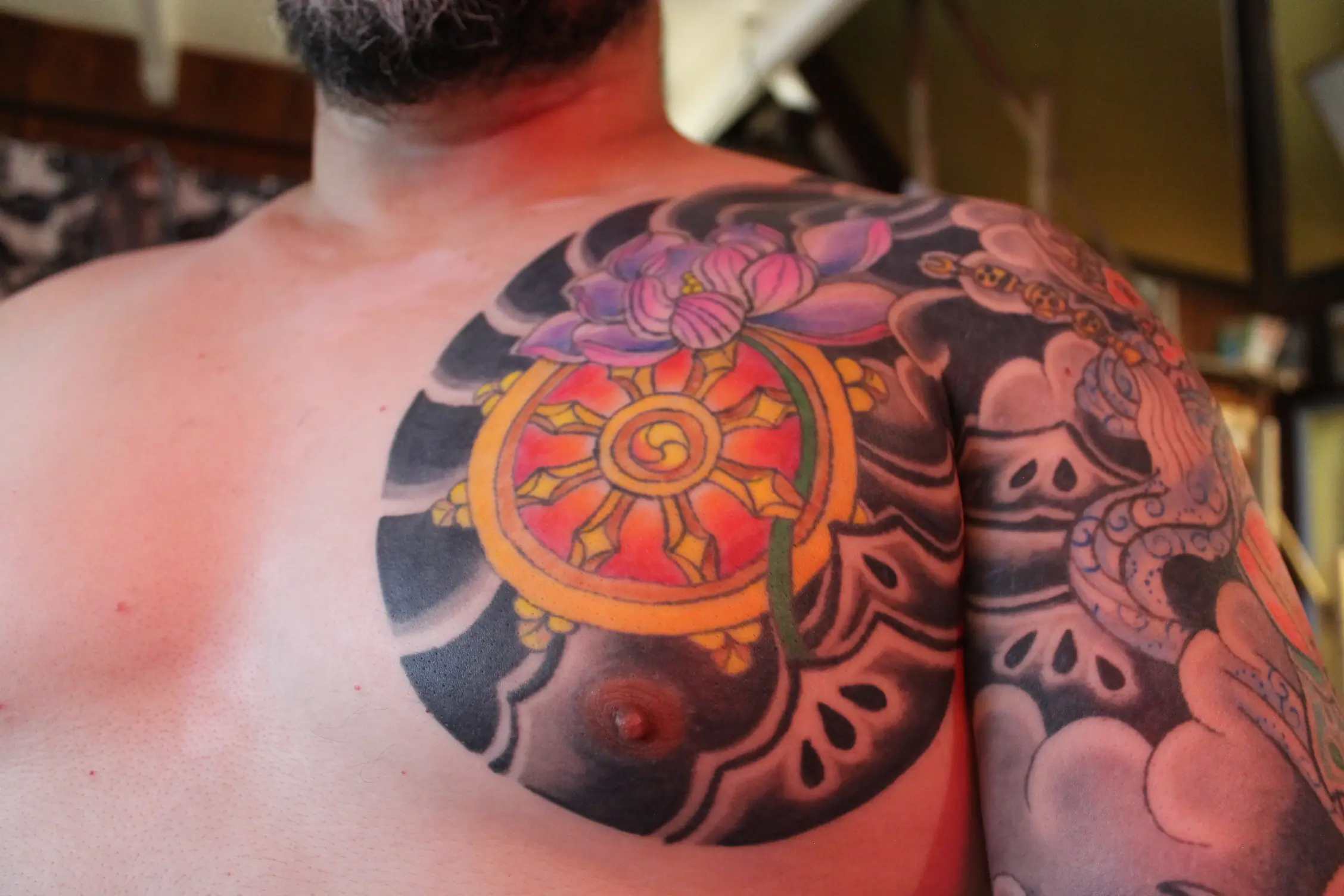 Espiral en el pecho con Rueda del Dharma en tatuaje japonés tradicional